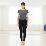 フィットネススタジオで直立するO脚の女性。