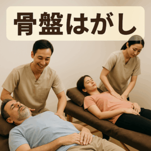 生成済み（テキストなし）。内容：施術ベッドで骨盤まわりをほぐされている男女の写真風リアルイメージ。